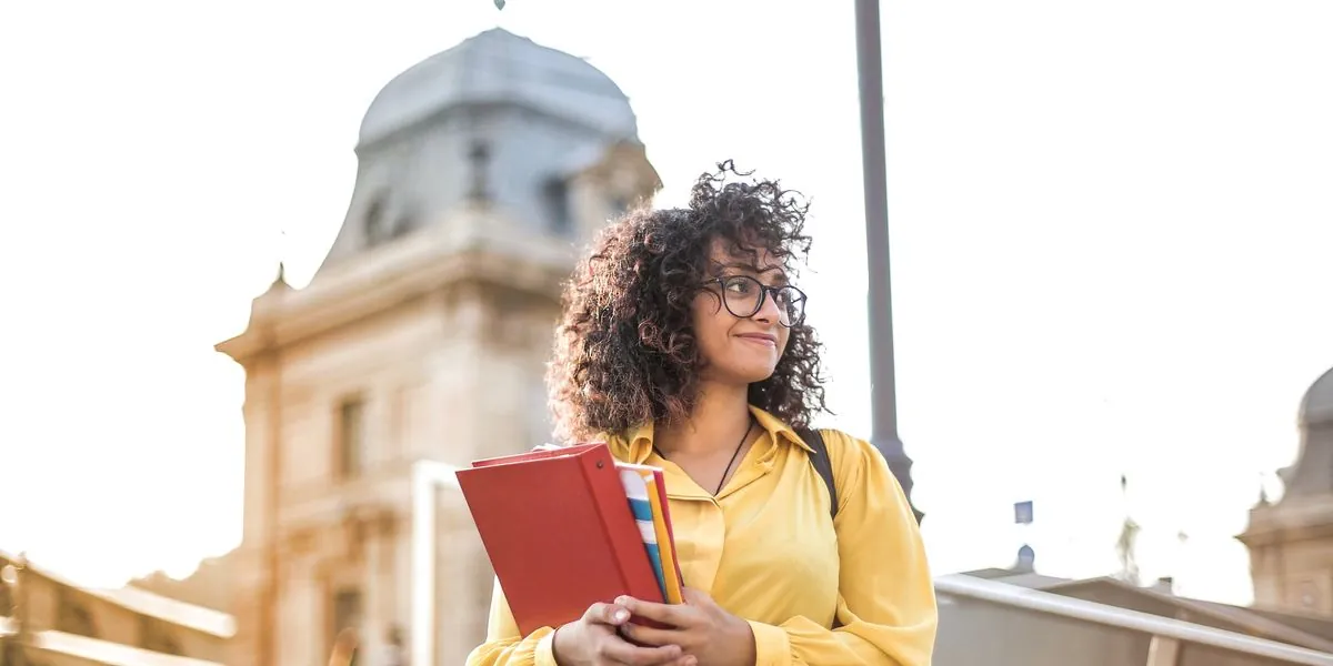 Candidata sorrindo com livros na mão