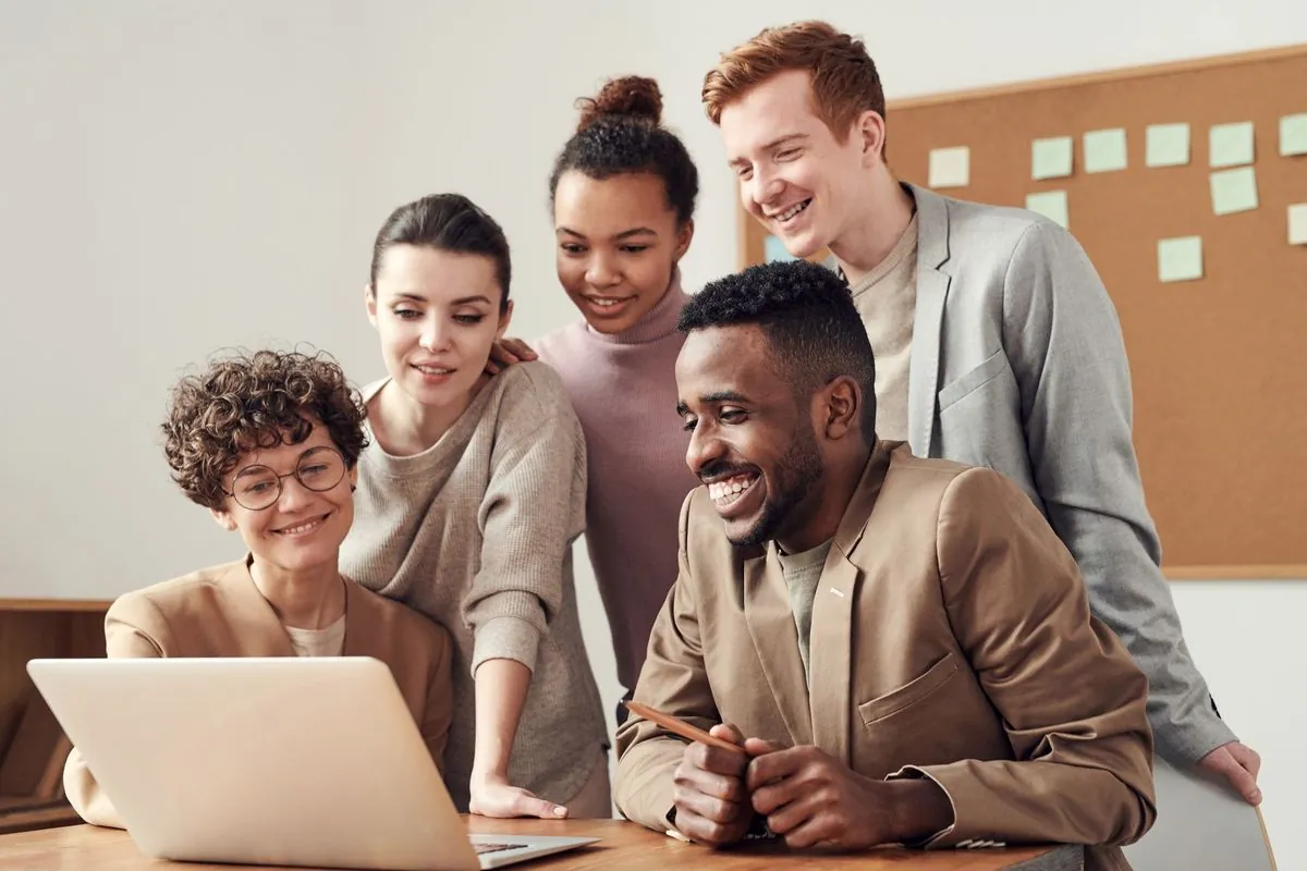 Equipe de RH reunida em volta de um notebook