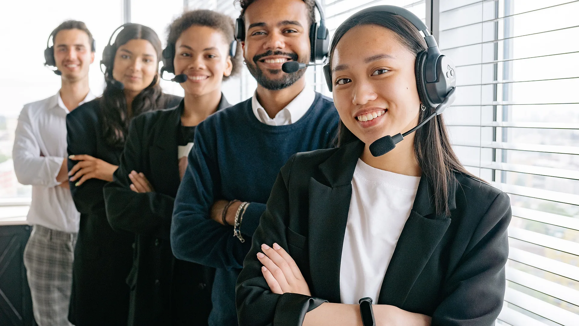 Equipe de atendimento sorrindo com headsets